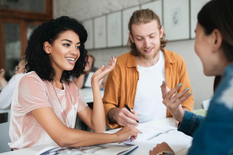 Three people looking happy while in a meeting