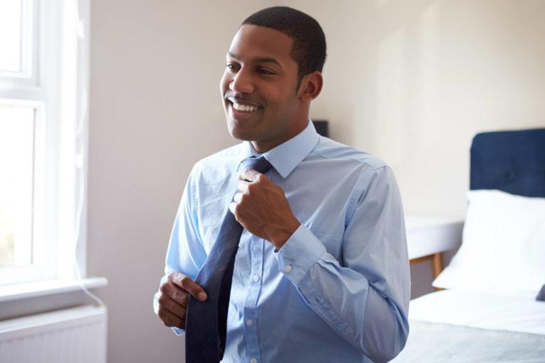 young african american man putting on tie