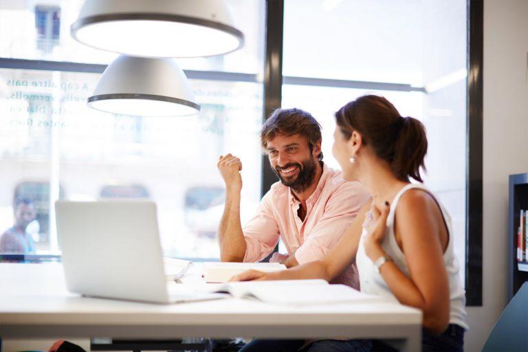 Collegues smiling while discussing a project